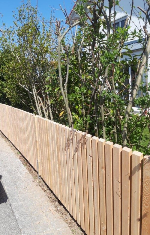 Schlichter Holzzaun mit Bepflanzung als Grundstücksabgrenzung